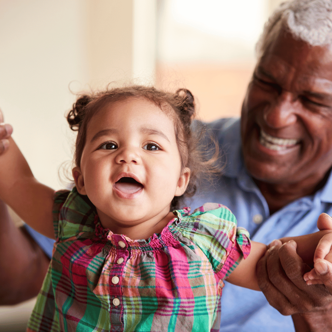 Grandfather playing with happy granddaughter